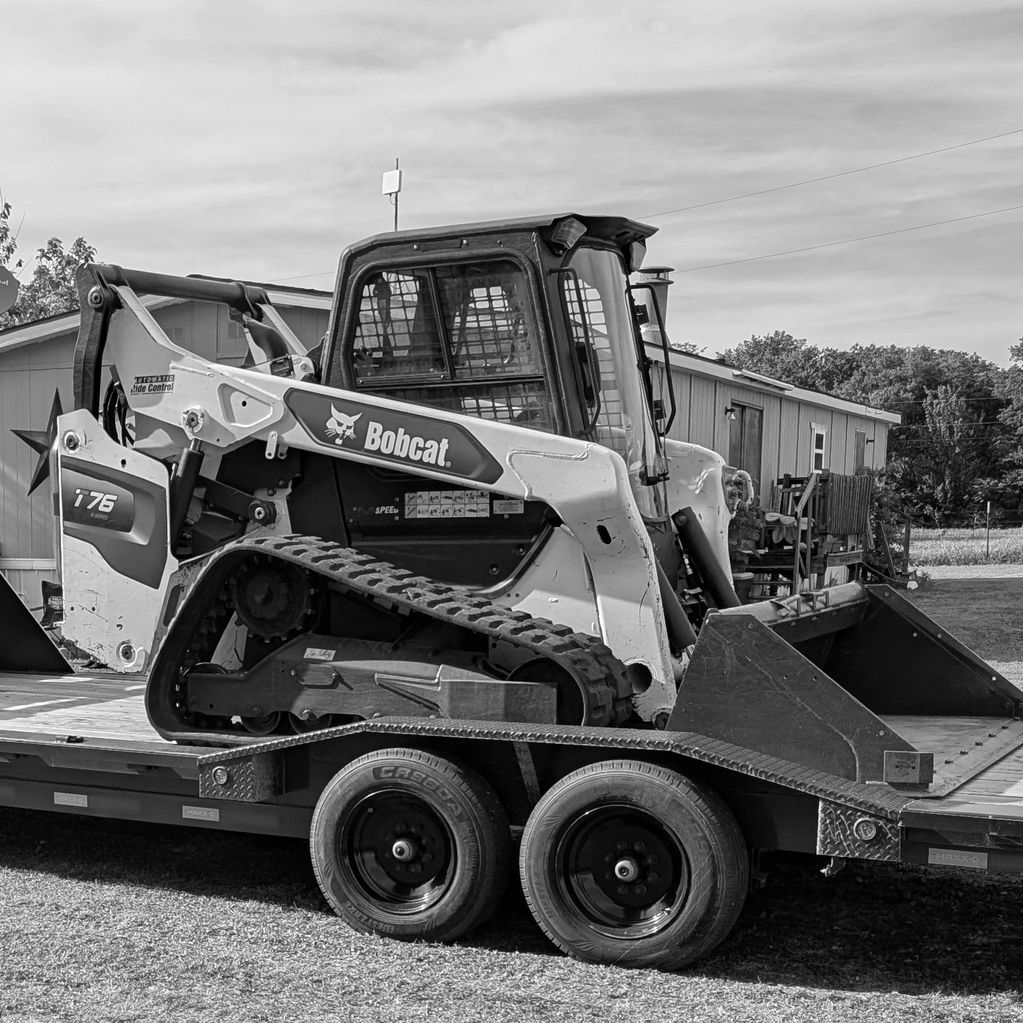Bobcat compact track loader on a trailer.