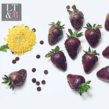 Dark chocolate covered strawberries with purple luster dust and hand piped chocolate designs 