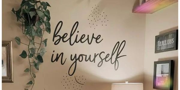 Cozy corner with inspirational wall art and green plants.