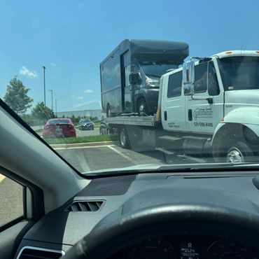 A tow truck carrying an Amazon Prime delivery van.