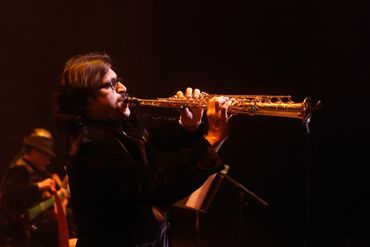 Musician playing saxophone on stage.

