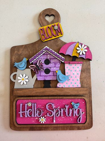Colorful wooden spring-themed decoration with birds, flowers, and text.