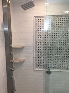 Tiled shower with accent wall and granite shelves