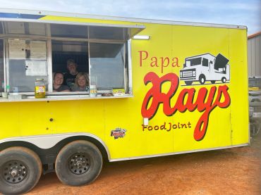 Workers greet guests from the yellow Papa Rays FoodJoint truck at the 2023 Doyle Boil.