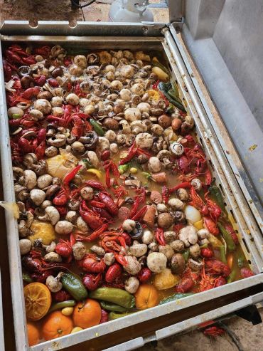 A large cooker filled with crawfish, mushrooms, corn, and vegetables at the 2024 Doyle Boil.