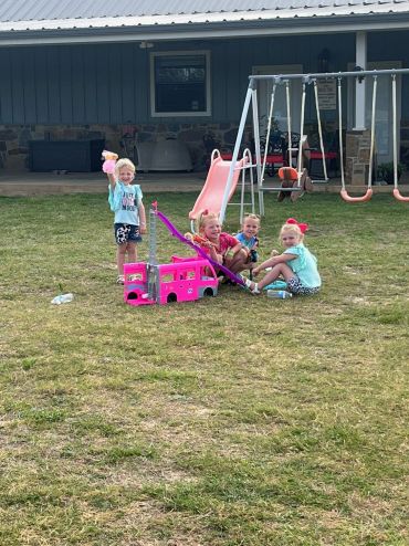 Four girls beside the outdoor playset at the 2023 Doyle Boil.