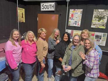 Eight smiling guests pose together inside the event venue at the 2024 Doyle Boil.