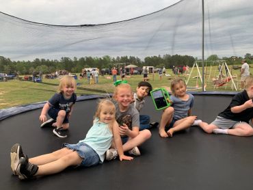 Children enjoy the trampoline with the event grounds in the background at the 2024 Doyle Boil.