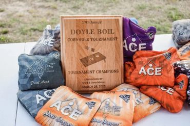 The 2025 Doyle Boil cornhole tournament trophy with colorful cornhole bags.