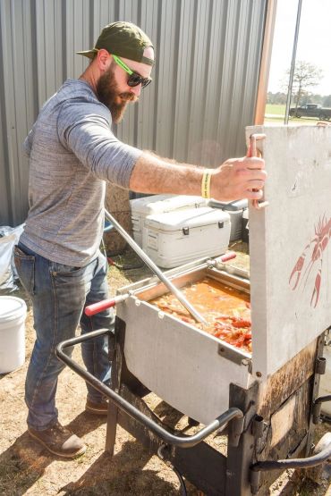 A cook opens a large cooker filled with crawfish at the 2025 Doyle Boil.