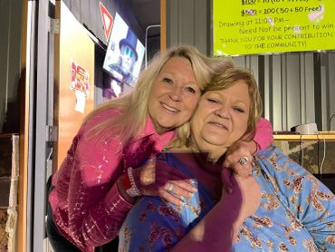 Two guests smile together beside the venue entrance at the 2024 Doyle Boil.