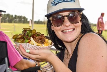 A smiling guest holds a tray of crawfish and vegetables at the 2025 Doyle Boil.