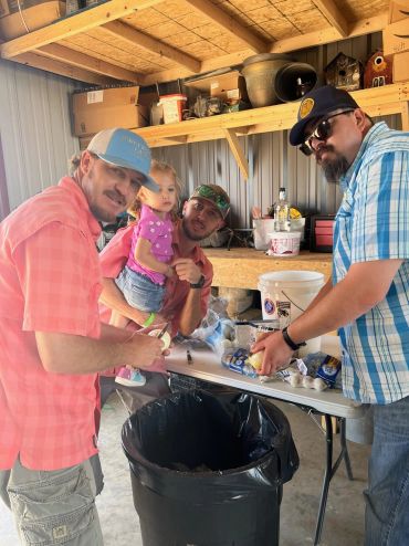 The cooking team prepares ingredients with a young helper at the 2023 Doyle Boil.