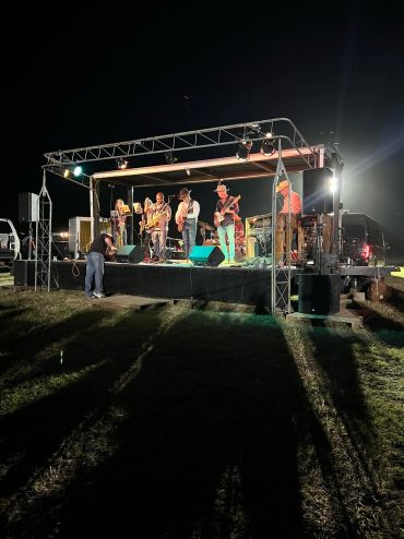 Musicians perform on the illuminated outdoor stage at the 2023 Doyle Boil.