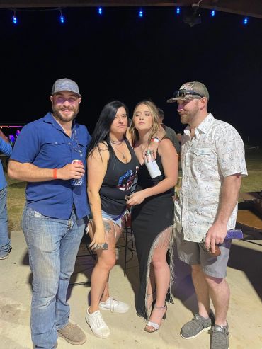 Four guests pose together under the outdoor string lights at the 2024 Doyle Boil.