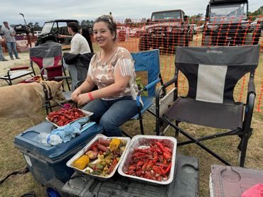 A guest sits beside trays of crawfish and vegetables at the 2026 Doyle Boil.