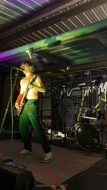 A singer and guitarist performs under colorful stage lighting at the 2026 Doyle Boil.