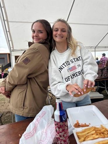 Two friends smile at the food tent at the 2026 Doyle Boil.
