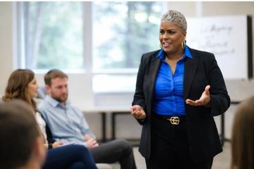 Confident woman speaking during a group meeting or workshop.