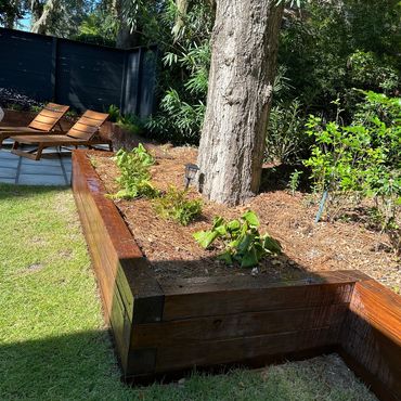 Custom backyard retaining wall built to support outdoor living in a coastal home landscape.