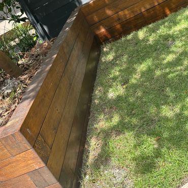 Custom backyard retaining wall built to support outdoor living in a coastal home landscape.