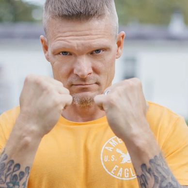 Man with tattoos in fighting stance.