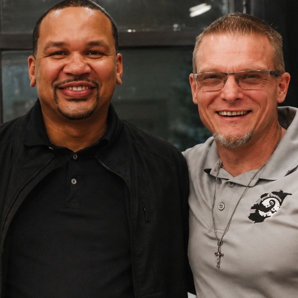 Two men smiling and posing together.