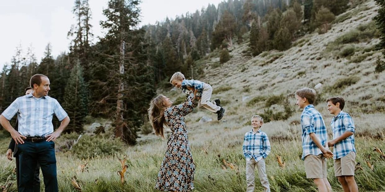 Family enjoying playful moment outdoors in nature.