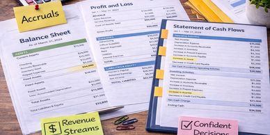 Financial documents on a desk with notes on accruals, revenue streams, and confident decisions.