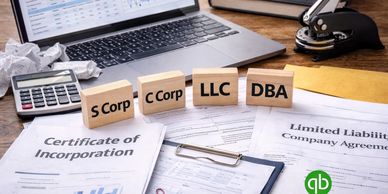 Business entity types and incorporation documents on a desk with a laptop and calculator.
