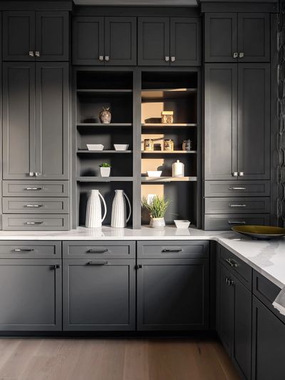 Modern kitchen with dark gray cabinets and white marble countertops.