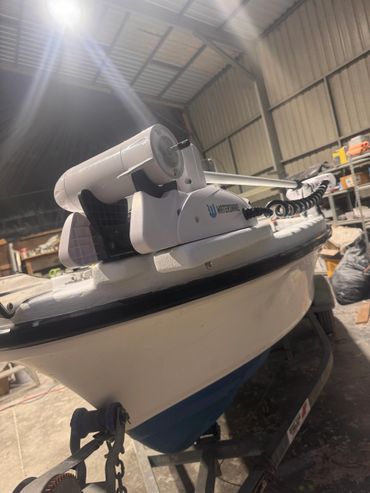 Close-up of a WaterSnake trolling motor mounted on a boat inside a storage shed.