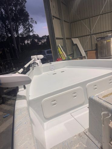 White boat interior with fishing equipment inside a shed at dusk.