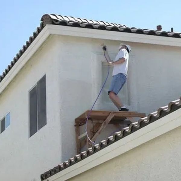 A man is on a roof, installing electrical components on a house