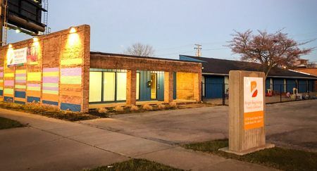 Modern brick building with colorful accents and sign in front.