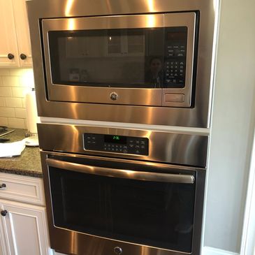 Modern stainless steel built-in microwave and oven in a kitchen.