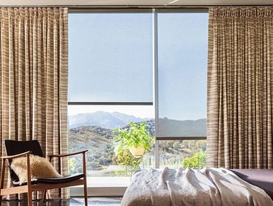 Cozy bedroom with large window and mountain view.