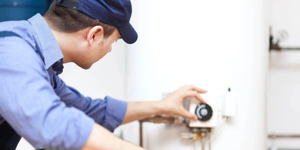 Smiling technician repairing an hot-water heater