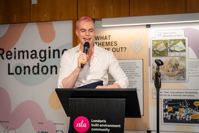 Benjamin O'Connor. Speaker with pink hair presents at London's built environment community event