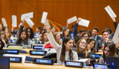 Delegates raising placards in a conference setting.