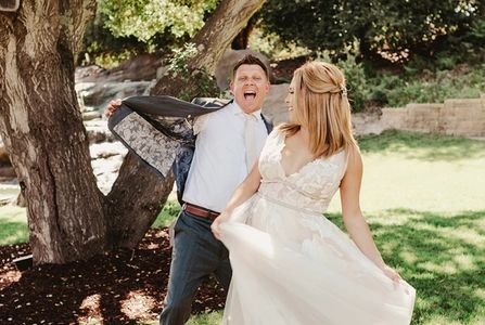 Groom showing off his custom liner in his custom well fitting suit. Wool grey herringbone suit.