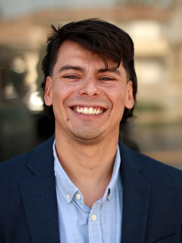 Smiling man in a blue suit jacket and light blue shirt.