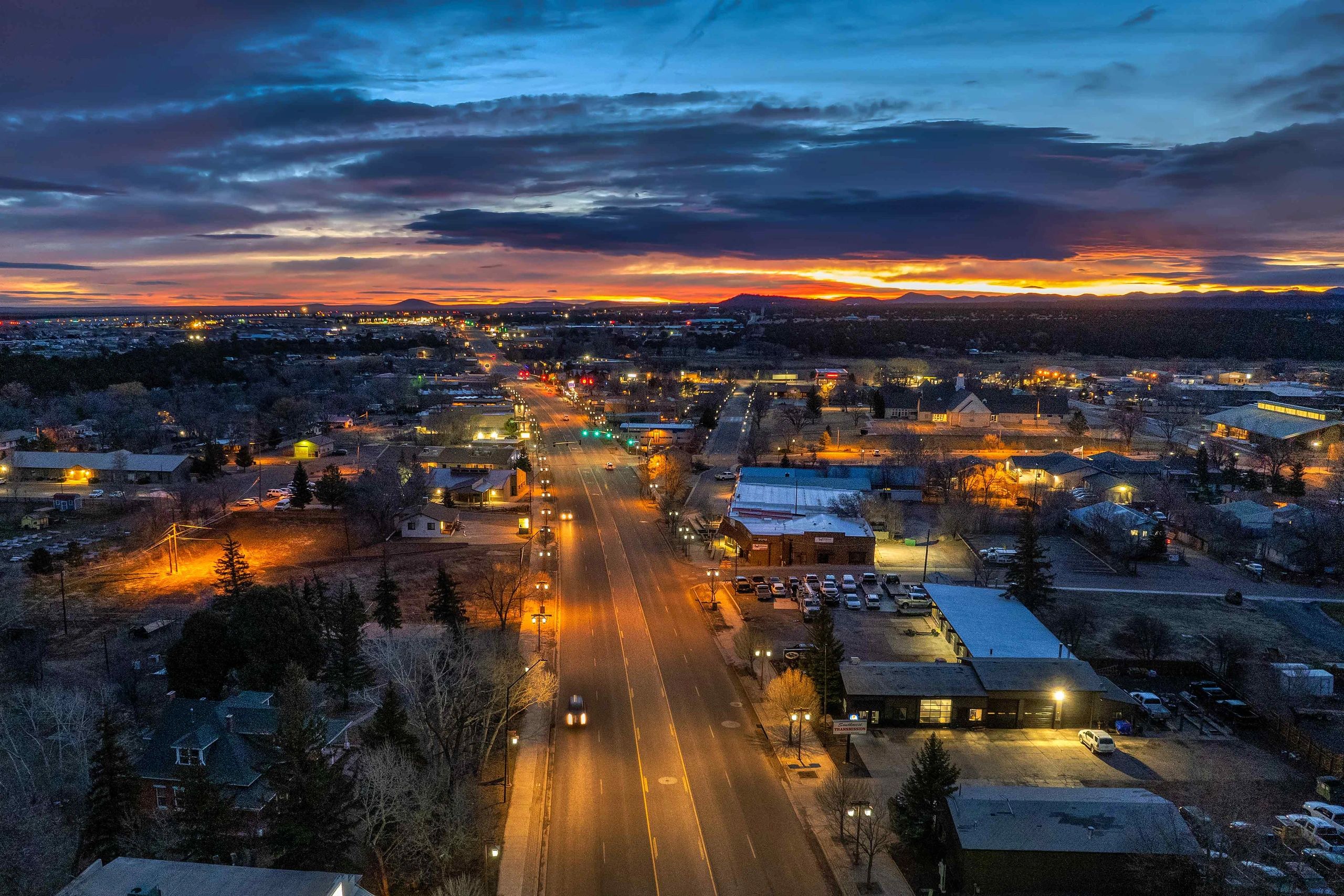Early morning picture of Show Low, Arizona with a sunrise, city lights.
