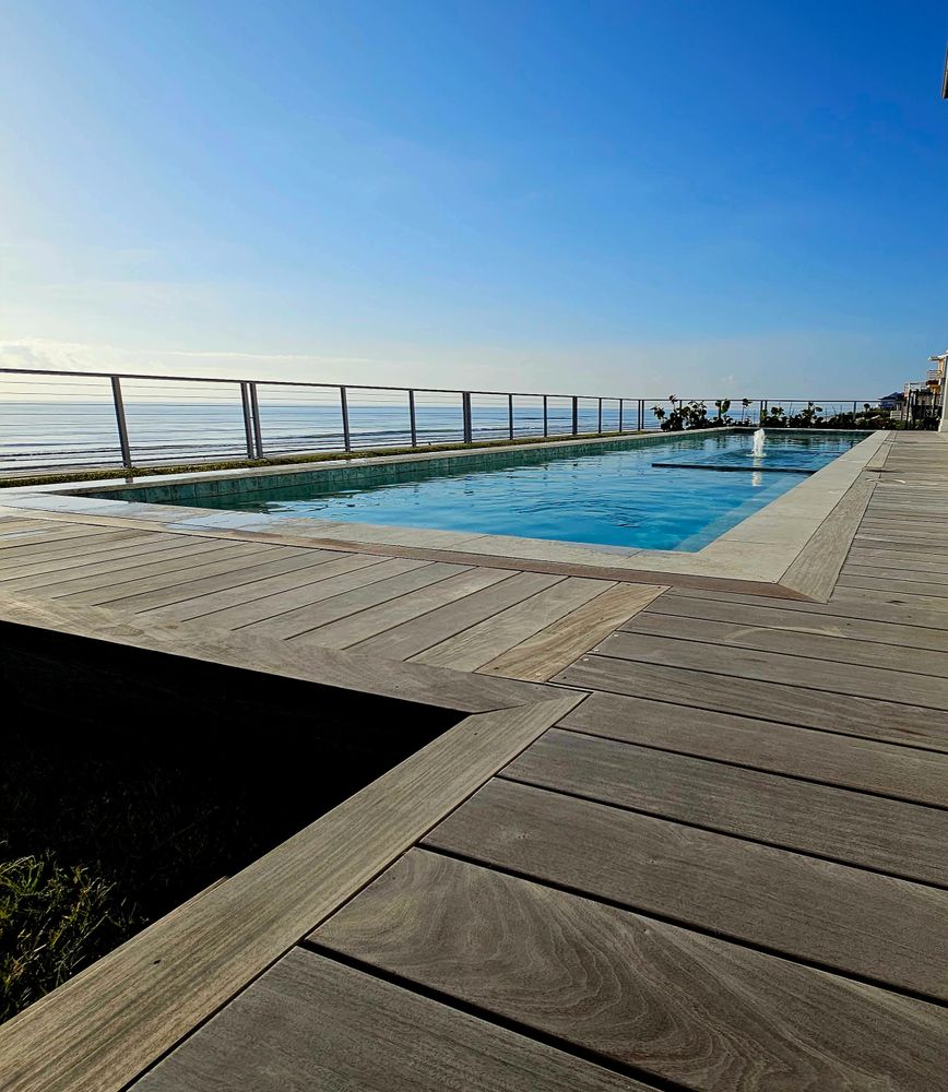 Beautifully maintained in-ground pool surrounded by tropical landscaping in New Smyrna Beach.