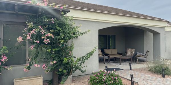 Cozy patio with outdoor seating and flowering plants.
