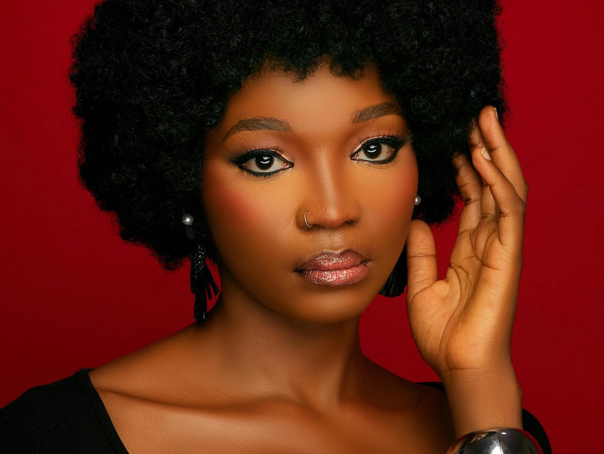 Une femme se maquille le visage et regarde devant elle