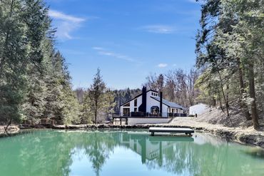 Pond view with dock featuring a home available for rent with airbnb and vrbo