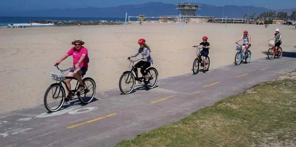 <img source="pic.jpg" alt="people riding bikes on the beach." />