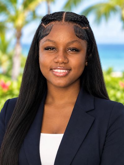 Young woman with long hair smiling outdoors.