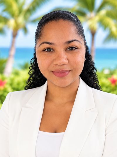 Smiling woman in white jacket with tropical background.